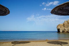 Η αμμώδης παραλία από κάτω από ήλιος-οι ομπρέλες στοκ φωτογραφία Η αμμώδης παραλία από κάτω από ήλιος-οι ομπρέλες στοκ φωτογραφία