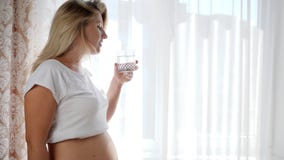 Η αναμένουσα γυναίκα τρίβει τη γυμνή κοιλιά της και πίνει το καθαρό νερό από το γυαλί σε σε αργή κίνηση στο άσπρο υπόβαθρο απόθεμα βίντεο Η αναμένουσα γυναίκα τρίβει τη γυμνή κοιλιά της και πίνει το καθαρό νερό από το γυαλί σε σε αργή κίνηση στο άσπρο υπόβαθρο απόθεμα βίντεο