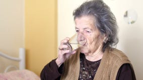 η ανθυγειινή ηλικιωμένη γυναίκα παίρνει τα χάπια, πίνει το νερό απόθεμα βίντεο η ανθυγειινή ηλικιωμένη γυναίκα παίρνει τα χάπια, πίνει το νερό απόθεμα βίντεο