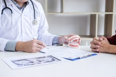 Η αρσενική εργασία εκθέσεων γραψίματος γιατρών ή οδοντιάτρων με το πρότυπο και τον εξοπλισμό των ακτίνων X ταινιών δοντιών χρησιμ στοκ φωτογραφία με δικαίωμα ελεύθερης χρήσης Η αρσενική εργασία εκθέσεων γραψίματος γιατρών ή οδοντιάτρων με το πρότυπο και τον εξοπλισμό των ακτίνων X ταινιών δοντιών χρησιμ στοκ φωτογραφία με δικαίωμα ελεύθερης χρήσης