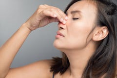 Η ασιατική γυναίκα βλάπτει τη μύτη της επειδή έχει το κρύο στοκ φωτογραφία Η ασιατική γυναίκα βλάπτει τη μύτη της επειδή έχει το κρύο στοκ φωτογραφία