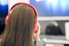 Η γυναίκα ακούει μουσική με την κόκκινη κάσκα της στοκ φωτογραφίες Η γυναίκα ακούει μουσική με την κόκκινη κάσκα της στοκ φωτογραφίες