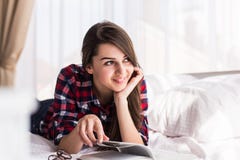 Η γυναίκα είναι άνετη να βρεθεί στο κρεβάτι της με ένα βιβλίο, χαμόγελο και ευτυχής και να ονειρευτεί στοκ φωτογραφία με δικαίωμα ελεύθερης χρήσης Η γυναίκα είναι άνετη να βρεθεί στο κρεβάτι της με ένα βιβλίο, χαμόγελο και ευτυχής και να ονειρευτεί στοκ φωτογραφία με δικαίωμα ελεύθερης χρήσης