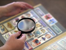 Η γυναίκα εξετάζει μέσω σημαδιών των πιό magnifier λευκωμάτων στοκ εικόνα Η γυναίκα εξετάζει μέσω σημαδιών των πιό magnifier λευκωμάτων στοκ εικόνα