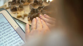 Η γυναίκα διαβάζει τη συνταγή και κάνει τις φόρμες για τη ζύμη απόθεμα βίντεο Η γυναίκα διαβάζει τη συνταγή και κάνει τις φόρμες για τη ζύμη απόθεμα βίντεο