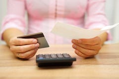 Η γυναίκα κρατά το λογαριασμό και την πιστωτική κάρτα στα χέρια και τον υπολογισμό στοκ εικόνες Η γυναίκα κρατά το λογαριασμό και την πιστωτική κάρτα στα χέρια και τον υπολογισμό στοκ εικόνες
