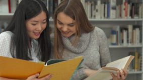 Η γυναίκα σπουδαστής δείχνει το δείκτη της στο βιβλίο στη βιβλιοθήκη στοκ φωτογραφία με δικαίωμα ελεύθερης χρήσης Η γυναίκα σπουδαστής δείχνει το δείκτη της στο βιβλίο στη βιβλιοθήκη στοκ φωτογραφία με δικαίωμα ελεύθερης χρήσης