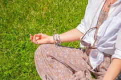 Η γυναίκα η συνεδρίαση στο Lotus θέτει στη χλόη στο πάρκο Ύφος Boho με τα εξαρτήματα, τα δαχτυλίδια και τα βραχιόλια στοκ φωτογραφία Η γυναίκα η συνεδρίαση στο Lotus θέτει στη χλόη στο πάρκο Ύφος Boho με τα εξαρτήματα, τα δαχτυλίδια και τα βραχιόλια στοκ φωτογραφία