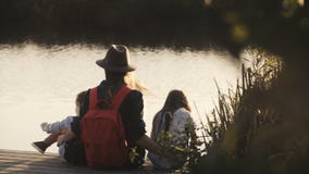 Η γυναίκα, το μικρό κορίτσι και το αγόρι κάθονται στην αποβάθρα στο ηλιοβασίλεμα Καταπληκτικός cinematic πυροβολισμός Ευτυχία Ένν φιλμ μικρού μήκους Η γυναίκα, το μικρό κορίτσι και το αγόρι κάθονται στην αποβάθρα στο ηλιοβασίλεμα Καταπληκτικός cinematic πυροβολισμός Ευτυχία Ένν φιλμ μικρού μήκους