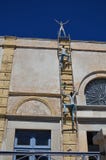 Η διακόσμηση του μη αναγνωρισμένου κτηρίου: Δύο άνδρες αναρριχούνται επάνω στη σκάλα στη γυναίκα Santorni, Ελλάδα στοκ φωτογραφία Η διακόσμηση του μη αναγνωρισμένου κτηρίου: Δύο άνδρες αναρριχούνται επάνω στη σκάλα στη γυναίκα Santorni, Ελλάδα στοκ φωτογραφία