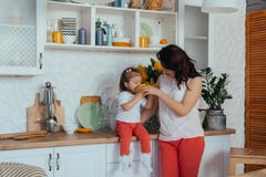 Η ελκυστικές νέες γυναίκα και λίγη χαριτωμένη κόρη μαγειρεύουν στην κουζίνα στοκ εικόνες Η ελκυστικές νέες γυναίκα και λίγη χαριτωμένη κόρη μαγειρεύουν στην κουζίνα στοκ εικόνες