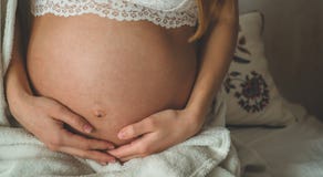 Η ελκυστική έγκυος γυναίκα κάθεται στο κρεβάτι και κρατά την κοιλιά της Τελευταίοι μήνες της εγκυμοσύνης στοκ φωτογραφία Η ελκυστική έγκυος γυναίκα κάθεται στο κρεβάτι και κρατά την κοιλιά της Τελευταίοι μήνες της εγκυμοσύνης στοκ φωτογραφία