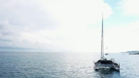 Η εναέρια άποψη της δεμένης στάσης γιοτ καταμαράν και οι άνθρωποι μπορούν κάνοντας ηλιοθεραπεία σε το είναι γέφυρα απόθεμα βίντεο Η εναέρια άποψη της δεμένης στάσης γιοτ καταμαράν και οι άνθρωποι μπορούν κάνοντας ηλιοθεραπεία σε το είναι γέφυρα απόθεμα βίντεο
