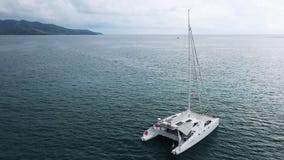 Η εναέρια άποψη της δεμένης στάσης γιοτ καταμαράν και οι άνθρωποι μπορούν κάνοντας ηλιοθεραπεία σε το είναι γέφυρα απόθεμα βίντεο Η εναέρια άποψη της δεμένης στάσης γιοτ καταμαράν και οι άνθρωποι μπορούν κάνοντας ηλιοθεραπεία σε το είναι γέφυρα απόθεμα βίντεο
