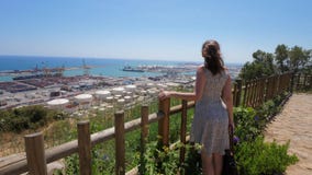 Η ευτυχής γυναίκα στο λόφο Montjuic απολαμβάνει τη θάλασσα και το πανόραμα λιμένων της Βαρκελώνης απόθεμα βίντεο Η ευτυχής γυναίκα στο λόφο Montjuic απολαμβάνει τη θάλασσα και το πανόραμα λιμένων της Βαρκελώνης απόθεμα βίντεο