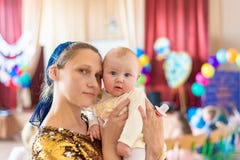 Η ευτυχής και χαρούμενη μητέρα κρατά το μωρό στα όπλα της, χαμογελά και εξετάζει τη κάμερα στοκ εικόνες Η ευτυχής και χαρούμενη μητέρα κρατά το μωρό στα όπλα της, χαμογελά και εξετάζει τη κάμερα στοκ εικόνες