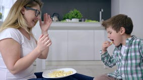 Η ευτυχής οικογένεια, μαμά με το παιδί παίζεται για τα γλυκά στη συνεδρίαση πιάτων στο πάτωμα στο εσωτερικό απόθεμα βίντεο Η ευτυχής οικογένεια, μαμά με το παιδί παίζεται για τα γλυκά στη συνεδρίαση πιάτων στο πάτωμα στο εσωτερικό απόθεμα βίντεο
