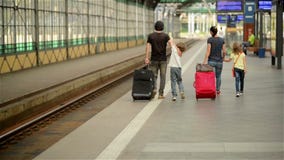 Η ευτυχής οικογένεια με το μικρό κορίτσι και το αγόρι που πηγαίνουν στο σιδηροδρομικό σταθμό, ο πατέρας μητέρων και τα παιδιά περ απόθεμα βίντεο Η ευτυχής οικογένεια με το μικρό κορίτσι και το αγόρι που πηγαίνουν στο σιδηροδρομικό σταθμό, ο πατέρας μητέρων και τα παιδιά περ απόθεμα βίντεο