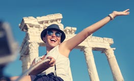 Η ευτυχής χαμογελώντας νέα γυναίκα παίρνει μια φωτογραφία selfie στις παλαιές θέες στοκ εικόνα Η ευτυχής χαμογελώντας νέα γυναίκα παίρνει μια φωτογραφία selfie στις παλαιές θέες στοκ εικόνα