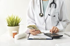 Η ιατρική αμοιβή, ασφάλεια υγείας, τραπεζογραμμάτια δολαρίων εκμετάλλευσης γιατρών και υπολογίζει τις δαπάνες εξέτασης στοκ εικόνα Η ιατρική αμοιβή, ασφάλεια υγείας, τραπεζογραμμάτια δολαρίων εκμετάλλευσης γιατρών και υπολογίζει τις δαπάνες εξέτασης στοκ εικόνα