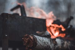 Η κατσαρόλα στέκεται κοντά στην πυρκαγιά, που θερμαίνεται για το τσάι ή τον καφέ στοκ εικόνες Η κατσαρόλα στέκεται κοντά στην πυρκαγιά, που θερμαίνεται για το τσάι ή τον καφέ στοκ εικόνες