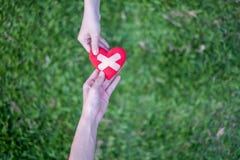 Η κόκκινη καρδιά στα χέρια της γυναίκας και τα χέρια των δύο ανδρών αποκαθίστανται Σημαίνει ότι η βοήθεια παραδίδει τις δύσκολες στοκ εικόνες Η κόκκινη καρδιά στα χέρια της γυναίκας και τα χέρια των δύο ανδρών αποκαθίστανται Σημαίνει ότι η βοήθεια παραδίδει τις δύσκολες στοκ εικόνες