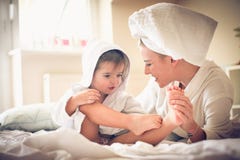 Η μαμά με τρίβει πόδι Μικρό κορίτσι με τη μητέρα της μετά από το λουτρό στοκ εικόνα με δικαίωμα ελεύθερης χρήσης Η μαμά με τρίβει πόδι Μικρό κορίτσι με τη μητέρα της μετά από το λουτρό στοκ εικόνα με δικαίωμα ελεύθερης χρήσης