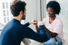 Η μικτή γιόγκα πρακτικής ζευγών φυλών, θέτει στο ξύλινο πάτωμα εσωτερικό στοκ εικόνες με δικαίωμα ελεύθερης χρήσης Η μικτή γιόγκα πρακτικής ζευγών φυλών, θέτει στο ξύλινο πάτωμα εσωτερικό στοκ εικόνες με δικαίωμα ελεύθερης χρήσης