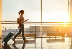 Η νέα γυναίκα πηγαίνει στον αερολιμένα στο παράθυρο με τη βαλίτσα περιμένοντας στοκ εικόνες με δικαίωμα ελεύθερης χρήσης Η νέα γυναίκα πηγαίνει στον αερολιμένα στο παράθυρο με τη βαλίτσα περιμένοντας στοκ εικόνες με δικαίωμα ελεύθερης χρήσης
