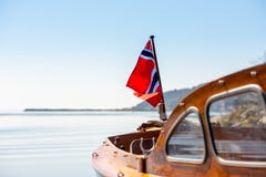 Η νορβηγική σημαία στον οπίσθιο ιστό μιας ξύλινης βάρκας στοκ εικόνες Η νορβηγική σημαία στον οπίσθιο ιστό μιας ξύλινης βάρκας στοκ εικόνες