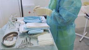 Η νοσοκόμα στα αποστειÏωμÎνα ενδÏματα και τα γάντια Ï€Ïοετοιμάζει τα ÏŒÏ απόθεμα βίντεο Η νοσοκόμα στα αποστειÏωμÎνα ενδÏματα και τα γάντια Ï€Ïοετοιμάζει τα ÏŒÏ απόθεμα βίντεο