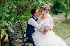 Η νύφη κάθεται στα όπλα του fiance της, το οποίο κρατά ήπια το πηγούνι και τις στροφές της σε τον για ένα φιλί Τα ευτυχή newlywed στοκ φωτογραφία με δικαίωμα ελεύθερης χρήσης Η νύφη κάθεται στα όπλα του fiance της, το οποίο κρατά ήπια το πηγούνι και τις στροφές της σε τον για ένα φιλί Τα ευτυχή newlywed στοκ φωτογραφία με δικαίωμα ελεύθερης χρήσης