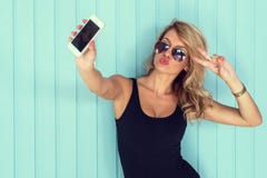 Η ξανθή γυναίκα στο κομπινεζόν με το τέλειο σώμα που παίρνει selfie το smartphone τόνισε instagram το φίλτρο Η ξανθή γυναίκα στο κομπινεζόν με το τέλειο σώμα που παίρνει selfie το smartphone τόνισε instagram το φίλτρο