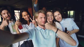 Η ομάδα συναδέλφων παίρνει selfie μαζί, ο νεαρός άνδρας κρατά τη κάμερα και θέτοντας, οι συνάδελφοί του κρατούν τα ποτά απόθεμα βίντεο Η ομάδα συναδέλφων παίρνει selfie μαζί, ο νεαρός άνδρας κρατά τη κάμερα και θέτοντας, οι συνάδελφοί του κρατούν τα ποτά απόθεμα βίντεο