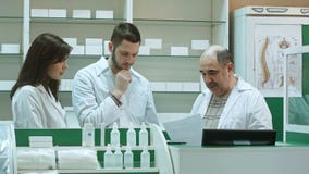 Η ομάδα των φαρμακοποιών που εργάζονται στο φαρμακείο φαρμακείων, ανώτερος φαρμακοποιός δεν ικανοποιεί με την εργασία σπουδαστών στοκ εικόνες Η ομάδα των φαρμακοποιών που εργάζονται στο φαρμακείο φαρμακείων, ανώτερος φαρμακοποιός δεν ικανοποιεί με την εργασία σπουδαστών στοκ εικόνες