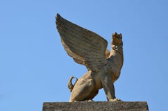 Η πέτρα griffin κάθεται σε ένα βάθρο ενάντια στο μπλε ουρανό στοκ εικόνα με δικαίωμα ελεύθερης χρήσης Η πέτρα griffin κάθεται σε ένα βάθρο ενάντια στο μπλε ουρανό στοκ εικόνα με δικαίωμα ελεύθερης χρήσης