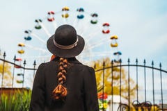 Η πίσω άποψη ενός νέου κοριτσιού στο καπέλο που στέκεται μπροστά από τα ferris κυλά στο λούνα παρκ στοκ φωτογραφία με δικαίωμα ελεύθερης χρήσης Η πίσω άποψη ενός νέου κοριτσιού στο καπέλο που στέκεται μπροστά από τα ferris κυλά στο λούνα παρκ στοκ φωτογραφία με δικαίωμα ελεύθερης χρήσης