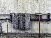 Η παλαιά σφουγγαρίστρα βάζει στη ράγα χάλυβα στην ξηρά, παλαιά στρόφιγγα και την παλαιά λαστιχένια μάνικα, παλαιό υπόβαθρο τοίχων στοκ εικόνα Η παλαιά σφουγγαρίστρα βάζει στη ράγα χάλυβα στην ξηρά, παλαιά στρόφιγγα και την παλαιά λαστιχένια μάνικα, παλαιό υπόβαθρο τοίχων στοκ εικόνα
