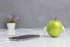 Η πράσινη Apple την κάσκα που συνδέεται με με το τηλέφωνο στοκ εικόνα με δικαίωμα ελεύθερης χρήσης Η πράσινη Apple την κάσκα που συνδέεται με με το τηλέφωνο στοκ εικόνα με δικαίωμα ελεύθερης χρήσης