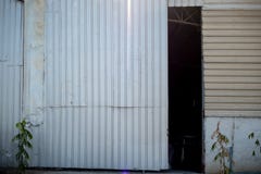 Η πόρτα της αποθήκης εμπορευμάτων που ανοίγει ελαφρώς για να δει το σκοτάδι μέσα για το υπόβαθρο στοκ εικόνες Η πόρτα της αποθήκης εμπορευμάτων που ανοίγει ελαφρώς για να δει το σκοτάδι μέσα για το υπόβαθρο στοκ εικόνες