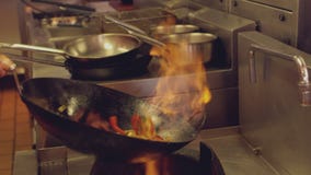 Η ρίψη αρχιμαγείρων που φλέγεται ανακατώνει τα τηγανητά απόθεμα βίντεο Η ρίψη αρχιμαγείρων που φλέγεται ανακατώνει τα τηγανητά απόθεμα βίντεο