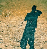 Η σκιά ενός ατόμου στην άμμο, ο ήλιος λάμπει στην πλάτη, τα επιπλέοντα σώματα σκιών στο τρίξιμο στοκ φωτογραφίες Η σκιά ενός ατόμου στην άμμο, ο ήλιος λάμπει στην πλάτη, τα επιπλέοντα σώματα σκιών στο τρίξιμο στοκ φωτογραφίες