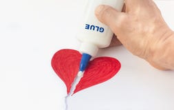 Η σπασμένη καρδιά εγγράφου καθορίζεται με την κόλλα σε ένα ανθρώπινο χέρι Στοκ εικόνα με δικαίωμα ελεύθερης χρήσης Η σπασμένη καρδιά εγγράφου καθορίζεται με την κόλλα σε ένα ανθρώπινο χέρι Στοκ εικόνα με δικαίωμα ελεύθερης χρήσης