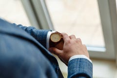 Η τοπ άποψη ενός ανθρώπινου παραδίδει ένα κοστούμι εξετάζοντας ένα wristwatch Ο επιχειρηματίας ελέγχει το χρόνο στο σύγχρονο wris στοκ φωτογραφία με δικαίωμα ελεύθερης χρήσης Η τοπ άποψη ενός ανθρώπινου παραδίδει ένα κοστούμι εξετάζοντας ένα wristwatch Ο επιχειρηματίας ελέγχει το χρόνο στο σύγχρονο wris στοκ φωτογραφία με δικαίωμα ελεύθερης χρήσης