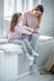 Η όμορφες νέες μητέρα και λίγη κόρη κάθονται από το παράθυρο μαζί και χρωματίζουν τα καρφιά τους Μητρική φροντίδα και αγάπη στοκ φωτογραφία με δικαίωμα ελεύθερης χρήσης Η όμορφες νέες μητέρα και λίγη κόρη κάθονται από το παράθυρο μαζί και χρωματίζουν τα καρφιά τους Μητρική φροντίδα και αγάπη στοκ φωτογραφία με δικαίωμα ελεύθερης χρήσης
