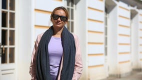 Η όμορφη γυναίκα στέκεται στο υπόβαθρο των παραθύρων ενός όμορφου σπιτιού και των χαμόγελων, εξετάζοντας τη κάμερα απόθεμα βίντεο Η όμορφη γυναίκα στέκεται στο υπόβαθρο των παραθύρων ενός όμορφου σπιτιού και των χαμόγελων, εξετάζοντας τη κάμερα απόθεμα βίντεο