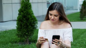 Η όμορφη νέα γυναίκα κάνει τις σε απευθείας σύνδεση αγορές χρησιμοποιώντας το τηλέφωνο, εισάγει μια συνεδρίαση αριθμών πιστωτικής απόθεμα βίντεο Η όμορφη νέα γυναίκα κάνει τις σε απευθείας σύνδεση αγορές χρησιμοποιώντας το τηλέφωνο, εισάγει μια συνεδρίαση αριθμών πιστωτικής απόθεμα βίντεο