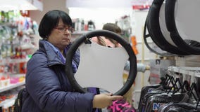 Η ώριμη γυναίκα επιλέγει μέσα μια μαλακή περιποίηση για το τιμόνι ενός αυτοκινήτου Η ώριμη γυναίκα επιλέγει μέσα μια μαλακή περιποίηση για το τιμόνι ενός αυτοκινήτου