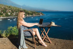 Θηλυκό που εργάζεται με το lap-top της κοντά στη θάλασσα Θηλυκό που εργάζεται με το lap-top της κοντά στη θάλασσα