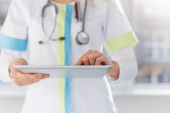 Θηλυκός γιατρός που χρησιμοποιεί ipad στην εργασία στο νοσοκομείο Στοκ Εικόνα Θηλυκός γιατρός που χρησιμοποιεί ipad στην εργασία στο νοσοκομείο Στοκ Εικόνα